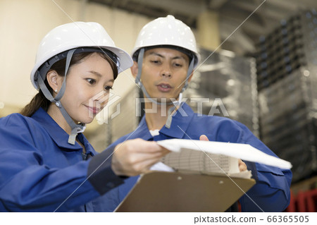 Male and female workers who check inventory control table in distribution warehouse Male and female workers who check inventory control table in distribution warehouse 66365505