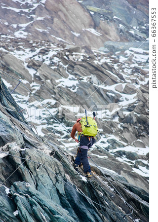 Alpinist climbing rocky mountain in Austria. 66367553