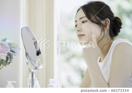 一名年輕女子在客廳裡照顧她的皮膚[擔心] 66373354