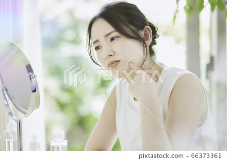 A young woman who cares for her skin in the living room [worried] 66373361