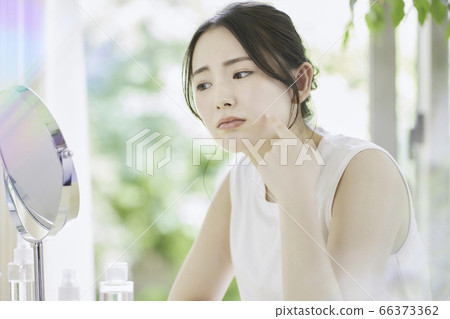 A young woman who cares for her skin in the living room [worried] 66373362