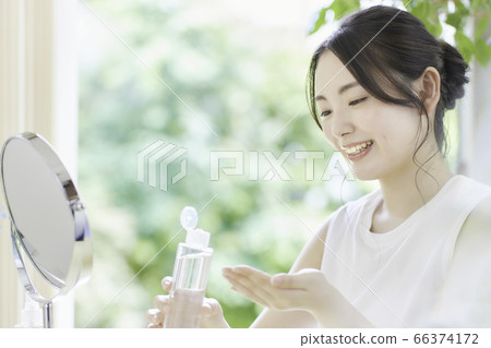 年輕女子在客廳裡照顧皮膚 年輕女子在客廳裡照顧皮膚 66374172