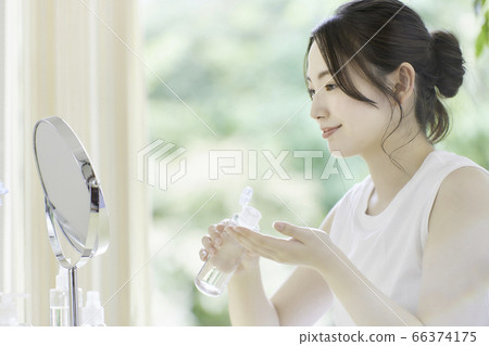 年輕女子在客廳裡照顧皮膚 年輕女子在客廳裡照顧皮膚 66374175