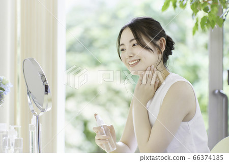 年輕女子在客廳裡照顧皮膚 年輕女子在客廳裡照顧皮膚 66374185