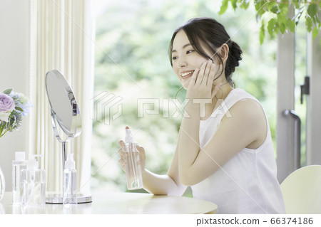年輕女子在客廳裡照顧皮膚 年輕女子在客廳裡照顧皮膚 66374186