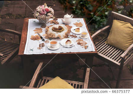 Afternoon tea basque burnt cheesecake and tea cup with teapot on wooden table. Afternoon tea basque burnt cheesecake and tea cup with teapot on wooden table. 66375377