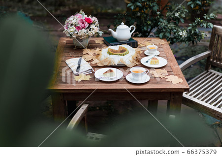 Afternoon tea basque burnt cheesecake and tea cup with teapot on wooden table. Afternoon tea basque burnt cheesecake and tea cup with teapot on wooden table. 66375379