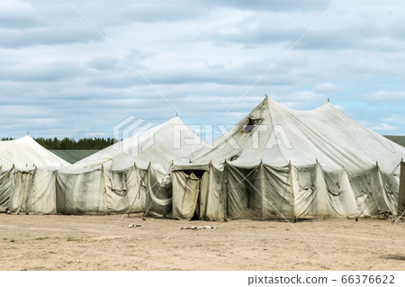 old soldiers ' tents torn in the wind in the field 66376622