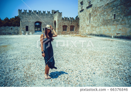 Happy woman traveler is walking and exploring Greek island of Rhodes, Dodecanese, Greece 66376846
