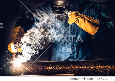 Metal welder working with arc welding machine. Metal welder working with arc welding machine. 66377722