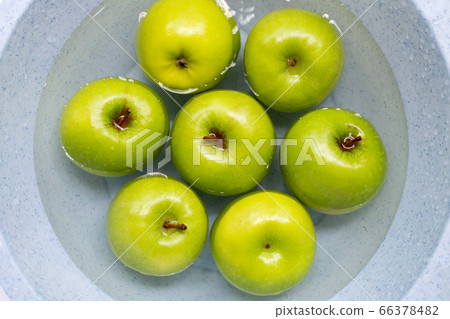 Soak green apples in water. Washing fruit concept Soak green apples in water. Washing fruit concept 66378482