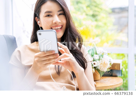 Beautiful woman Home room Living sofa Mobile phone Use music chat Enjoy material Beautiful woman Home room Living sofa Mobile phone Use music chat Enjoy material 66379138