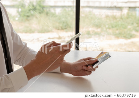 The hands of business people holding credit cards and smartphones for online shopping and paying via the internet 66379719