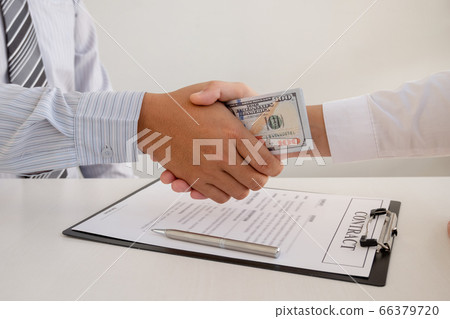photo of Businessmen shake hands and dollar note, sign a contract to bribe corruption in the company photo of Businessmen shake hands and dollar note, sign a contract to bribe corruption in the company 66379720