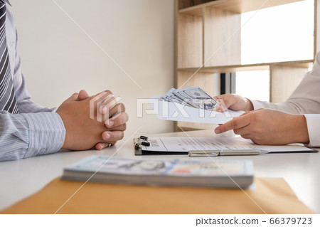 Businessmen make an agreement with the money proposed his partner to bribe in the company Businessmen make an agreement with the money proposed his partner to bribe in the company 66379723