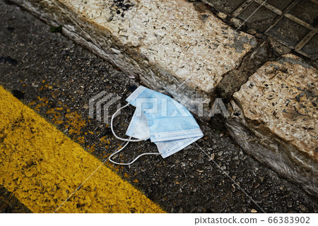 used surgical mask thrown on the asphalt 66383902