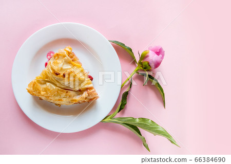 Top view of piece of cherry pie with peonies 66384690
