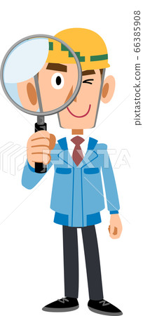 A man in a blue workwear wearing a helmet looking through a magnifying glass 66385908