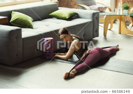 Sporty young woman practicing yoga at home 66386149