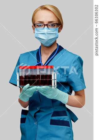medical doctor nurse woman wearing protective mask and gloves - holding rack with virus blood tests medical doctor nurse woman wearing protective mask and gloves - holding rack with virus blood tests 66386302