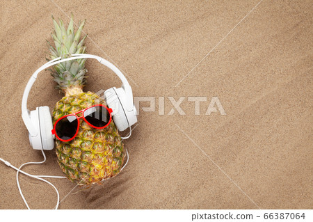 Ripe pineapple with sunglasses and headphones Ripe pineapple with sunglasses and headphones 66387064