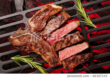 T-bone beef steak cooking on grill T-bone beef steak cooking on grill 66387143