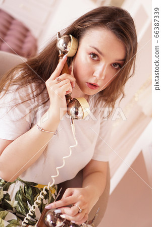 A woman talks on the phone. phone handset in retro style A woman talks on the phone. phone handset in retro style 66387339