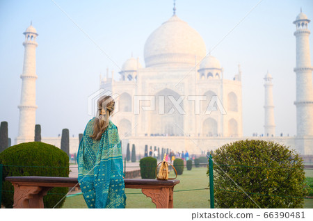 Portrait of young woman in Turquoise blue saree indian traditional dress against Taj Mahal Portrait of young woman in Turquoise blue saree indian traditional dress against Taj Mahal 66390481