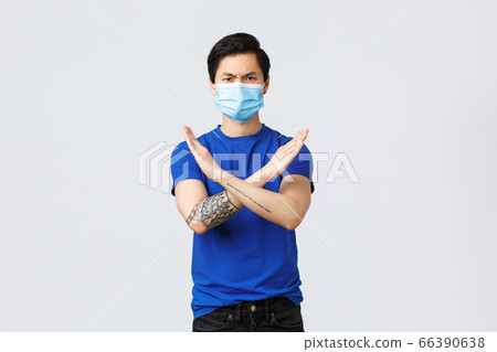 Different emotions, social distancing, quarantine on covid-19 and lifestyle concept. Guy against it. Asian man frowning disappointed and serious, rejecting or forbid something with cross stop sign 66390638