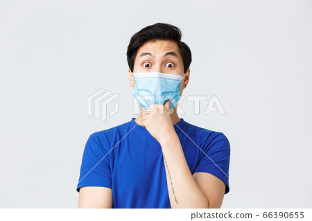 Different emotions, lifestyle and leisure during coronavirus, covid-19 concept. Close-up of intrigued asian guy listening to interesting suggestion, wear medical mask, touch chin and stare impressed Different emotions, lifestyle and leisure during coronavirus, covid-19 concept. Close-up of intrigued asian guy listening to interesting suggestion, wear medical mask, touch chin and stare impressed 66390655
