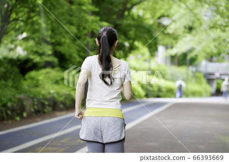 慢跑以新鮮綠色一名年輕女子的後視圖 慢跑以新鮮綠色一名年輕女子的後視圖 66393669