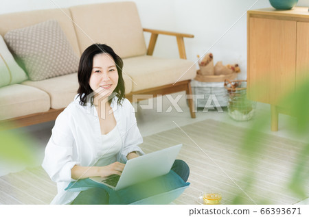 放鬆與在她的膝蓋上的一台計算機的中間女人 放鬆與在她的膝蓋上的一台計算機的中間女人 66393671