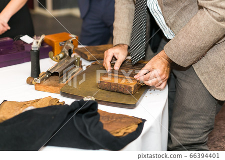 Demonstration of tobacco creation using classical hand made tools.  66394401