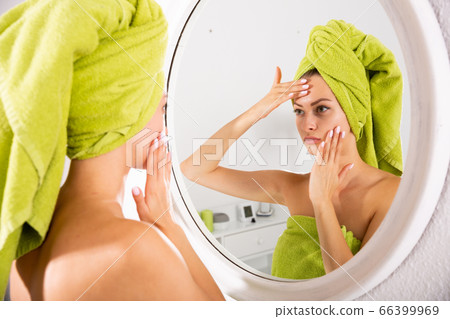 Woman touching her face Woman touching her face 66399969