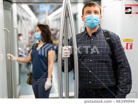 Passenger in medical mask riding in subway car Passenger in medical mask riding in subway car 66399994