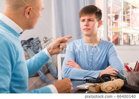 Serious father lecturing his son Serious father lecturing his son 66400140