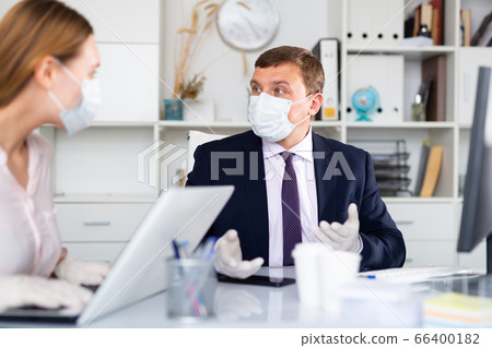 Director and secretary in protective masks work in the office Director and secretary in protective masks work in the office 66400182