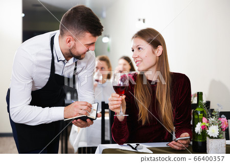 Waiter is taking order from young female in restaurante Waiter is taking order from young female in restaurante 66400357