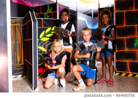 Multiracial kids posing on lasertag arena 66400556