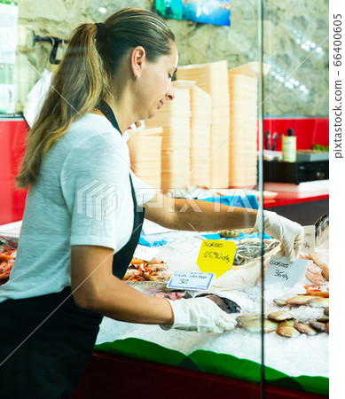 Female arranging seafood display of fish shop 66400605