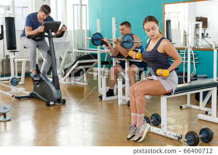 Sporty girl with dumbbells foreground Sporty girl with dumbbells foreground 66400712
