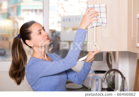 Smiling woman is cleaning surface on the kitchen at the home 66400862
