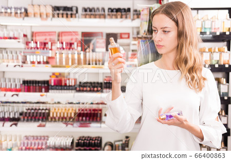 Woman choosing perfume in cosmetics store Woman choosing perfume in cosmetics store 66400863