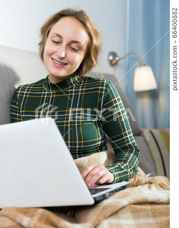 Woman resting with laptop on sofa 66400882