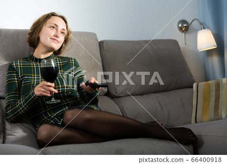Woman relaxing at home watching TV Woman relaxing at home watching TV 66400918