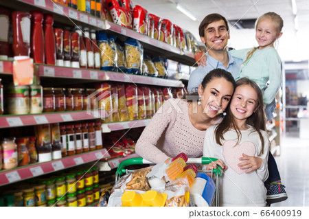 parents with two kids and purchases in shopping cart 66400919