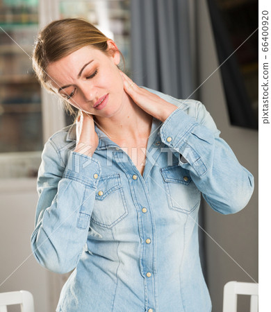 Portrait of a girl suffering from pain in the neck Portrait of a girl suffering from pain in the neck 66400920