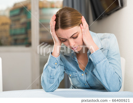 Upset woman sitting at table 66400921