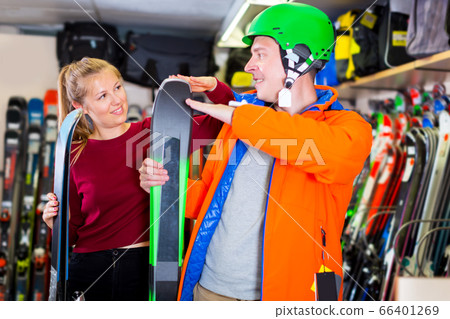 Saleswoman is helping man in ski equipment Saleswoman is helping man in ski equipment 66401269