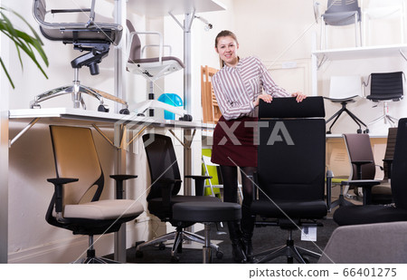 Smiling girl standing in chair shop Smiling girl standing in chair shop 66401275